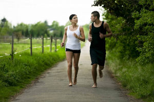 спортивная пара занимается босоногой пробежкой